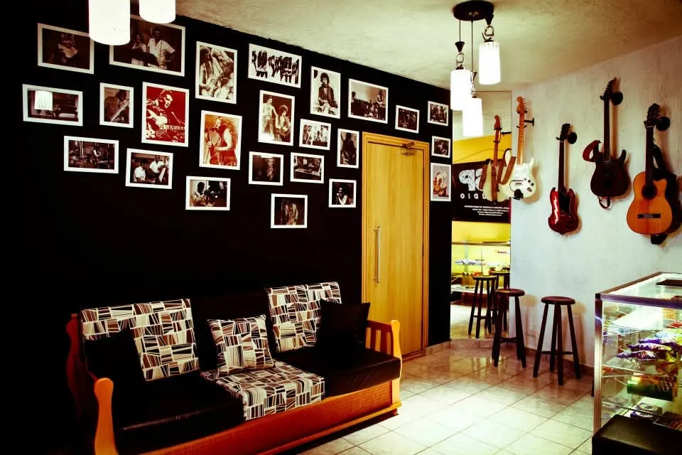 Lounge do estúdio com parede de fotos e instrumentos